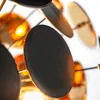 A close-up shot of a modern chandelier with multiple black and gold disc-shaped elements. Podgląd zdjęcia produktu