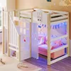 A child's loft bed with a slide and a pink sofa underneath, decorated with fairy lights and clouds. Voir les images du produit