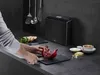 A person is cutting a pomegranate on a cutting board in a modern kitchen. Anteprima dell’immagine prodotto