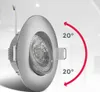 A close-up of a silver recessed spotlight with a red arc indicating its adjustable angle. Voir les images du produit