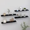 Four black wall shelves are mounted on a white wall, each displaying various decorative items. Podgląd zdjęcia produktu