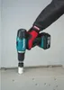 A hand wearing a glove is holding a cordless drill with a hole saw attachment, about to drill into a metal surface. Produktbild-Vorschau