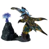 A toy diorama of a Na'vi character riding a sea creature, with alien flora on a rocky base. Produktbild-Vorschau
