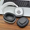 A disassembled pair of headphones and their earcups are laid out on a wooden surface, with a laptop in the background. Podgląd zdjęcia produktu