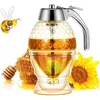 A honey dispenser with a honeycomb design, filled with honey, sits next to a honeycomb and a sunflower. A cartoon bee is flying nearby. Produktbild-Vorschau