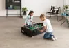 Two children are playing foosball on a table in a room. Anteprima dell’immagine prodotto