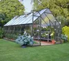 A greenhouse filled with plants in a garden setting. Produktbild-Vorschau