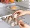 A person's hands are placing an egg into a transparent egg holder inside a refrigerator. Náhled obrázku produktu