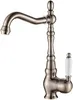 A single kitchen faucet with an antique brass finish and a white ceramic handle, isolated on a white background. Podgląd zdjęcia produktu