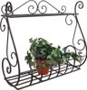 A black metal wall shelf with a potted ivy plant on it, against a white background. Náhľad obrázku produktu