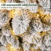 A close-up view of a flocked artificial Christmas tree with warm white LED lights. Podgląd zdjęcia produktu