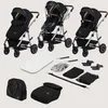 A collection of baby stroller components and accessories laid out on a light gray background. Produktbild-Vorschau