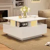 A modern white coffee table with built-in lighting and storage, placed in a living room setting with a fireplace and sofa. Podgląd zdjęcia produktu
