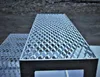 A close-up view of a metal staircase with a diamond plate pattern. Produktbild-Vorschau