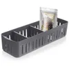 A gray plastic organizer with multiple compartments, containing a small bag of black peppercorns. Náhled obrázku produktu