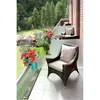 A balcony with plants and outdoor furniture, overlooking a green landscape. Produktbild-Vorschau