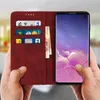 Hands holding a red flip cover wallet case for a Samsung Galaxy S10, with cards and banknotes inserted. Produktbild-Vorschau