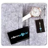 A watch and its accessories laid out on a gray felt organizer. Produktbild-Vorschau