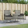 A two-seater outdoor sofa with a small table in between, set on a patio with a wooden fence and greenery in the background. Produktbild-Vorschau