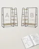 Two identical shelving units with a clothing rack, side by side, with an instruction manual open on a surface below. Produktbild-Vorschau