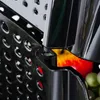A close-up view of a black storage container with holes, showing a glimpse of fruit inside. Náhled obrázku produktu