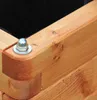 A close-up view of the corner of a wooden planter box, showing the construction detail and a metal bolt and nut. Produktbild-Vorschau