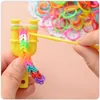 A close-up shot of hands using a yellow loom band maker to create a colorful bracelet. Náhled obrázku produktu