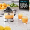 A citrus juicer is shown with oranges and limes in the background, and two glasses of juice in the foreground. Text overlays promote the product. Produktbild-Vorschau