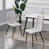 Two dining chairs are shown in a room setting, with a table and plant in the background.