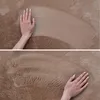 A close-up of a hand touching a soft, textured carpet. Podgląd zdjęcia produktu