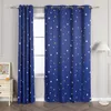 Two blue curtains with a star pattern are shown hanging in front of a window. A white floor lamp is to the right, and a white dresser with a framed picture is to the left. Produktbild-Vorschau