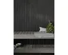 A sauna interior with wooden walls and benches, featuring a bundle of birch branches and a towel. Produktbild-Vorschau