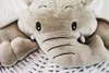 Close-up of a plush elephant toy peeking out from a white wicker laundry basket. Podgląd zdjęcia produktu