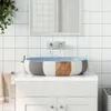 A bathroom sink with a colorful basin sits on a white vanity. White tiled walls and a mirror are in the background. Produktbild-Vorschau