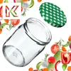 A glass jar and its lid are surrounded by various fresh vegetables and herbs, with a stylized 'K' logo in the top left corner. Podgląd zdjęcia produktu