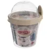 A clear studio shot of a yogurt cup with a spoon and a small inner bowl. Voir les images du produit