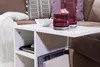 Weißer moderner Beistelltisch 50x50x30cm mit offenen Fächern, von vorne mit Getränkegläsern und Schale bestückt. Productafbeelding-voorbeeld
