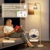 A woman is sitting on a couch reading a magazine, with a floor lamp in the background. Anteprima dell’immagine prodotto