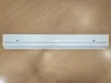 A white LED light fixture is mounted on a wooden surface. Produktbild-Vorschau