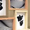 A collage of four framed pictures, featuring abstract black and white designs and a sculpture of a torso. Náhled obrázku produktu