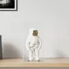 A white astronaut figurine inside a transparent display box, placed on a wooden shelf. Produktbild-Vorschau