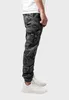A person is shown from the side wearing cargo pants and sneakers. Produktbild-Vorschau