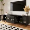 A black TV stand with glass doors and drawers, featuring decorative items and plants, in a living room setting. Anteprima dell’immagine prodotto