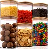 Six clear glass storage jars with bamboo lids, filled with different food items, arranged in a grid. Voir les images du produit