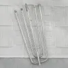 A close-up view of several metal curtain hooks resting on a textured white fabric. Voir les images du produit