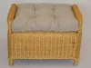 A close-up, front-facing view of a wicker ottoman with a tufted cushion. Produktbild-Vorschau
