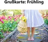 A person holding a basket of flowers in a garden with tulips. Produktbild-Vorschau