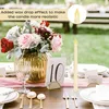 A table setting for an event, with flowers, candles, and table numbers. Náhled obrázku produktu