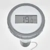 A close-up shot of a digital thermometer with a grey casing and a white face. Náhľad obrázku produktu