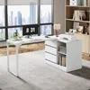 A modern white L-shaped desk with drawers and shelves is set up in a home office with a large window overlooking a city skyline. Voir les images du produit